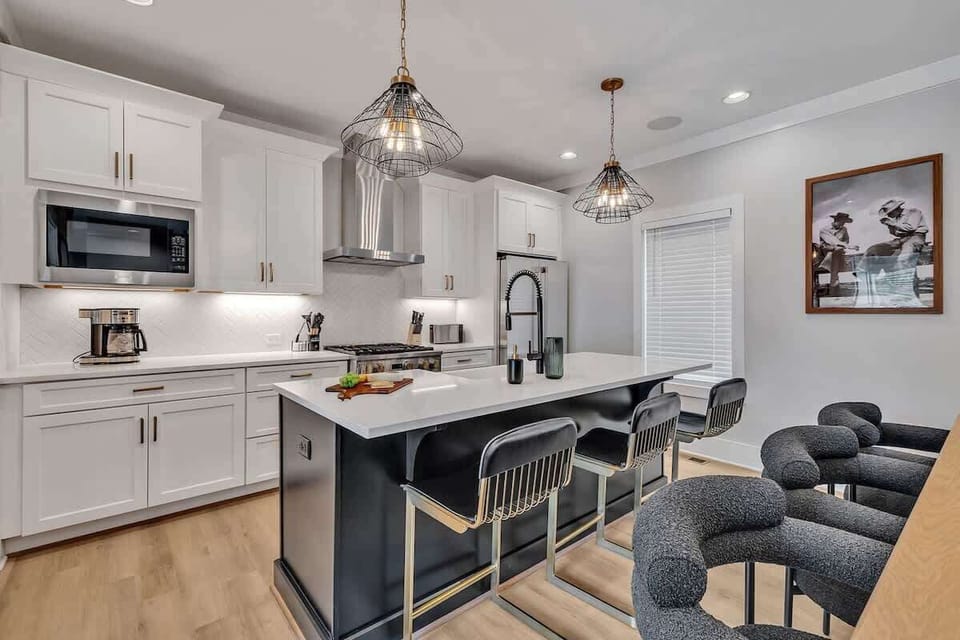 2nd Floor: Fully equipped kitchen stocked with all culinary essentials featuring Monogram stainless-steel appliances, a large kitchen island offering bar seating.
