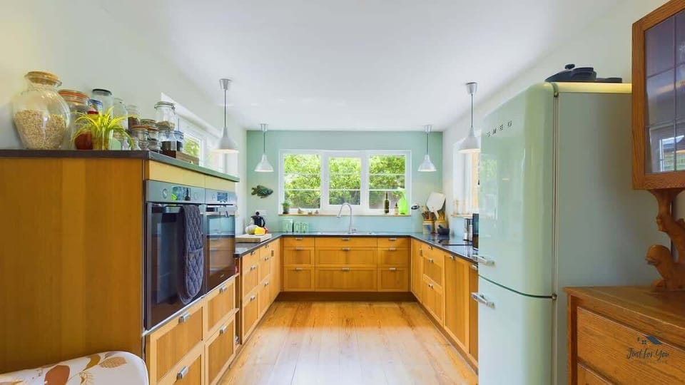 Close-up of kitchen appliances and workspace, including hob, oven, fridge and coffee station — perfect for self-catering.
