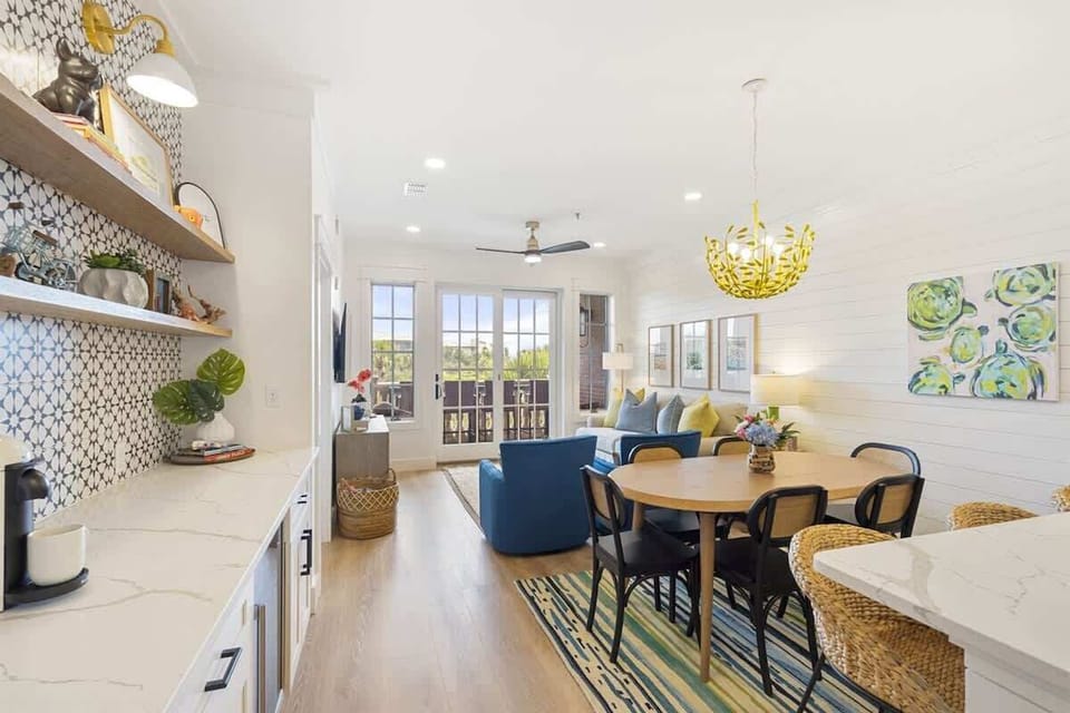 - Vibrant dining space flows seamlessly into the living room with seating for six and sunny vibes - Bold pendant lighting, shiplap walls, and colorful accents create a cheerful gathering place - Wall to wall windows lead to a breezy balcony just beyo