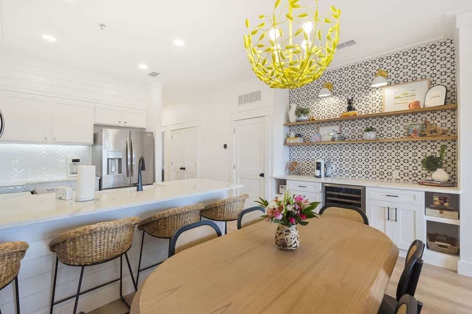 - Dine in style at this beautifully curated space featuring a wood table and island seating - Open shelves and bold tile make the kitchen area as functional as it is photo worthy - Perfect for sharing meals, sipping wine, or late night snacks