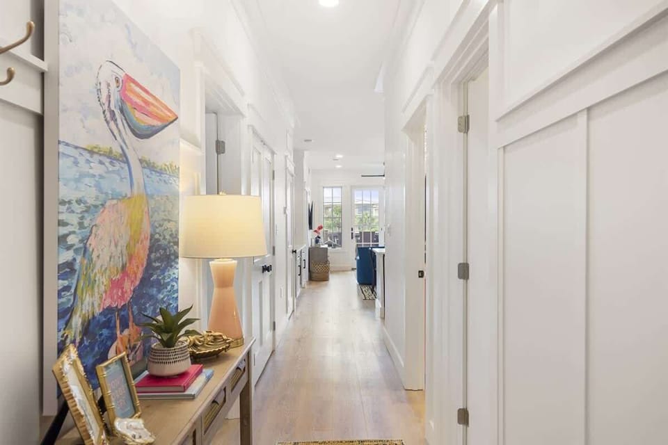 - Bright hallway greets you with vibrant artwork, soft lighting, and decorative touches - Coastal flair and thoughtful styling lead the way to the heart of the home - Charming first impression as soon as you walk through the door  