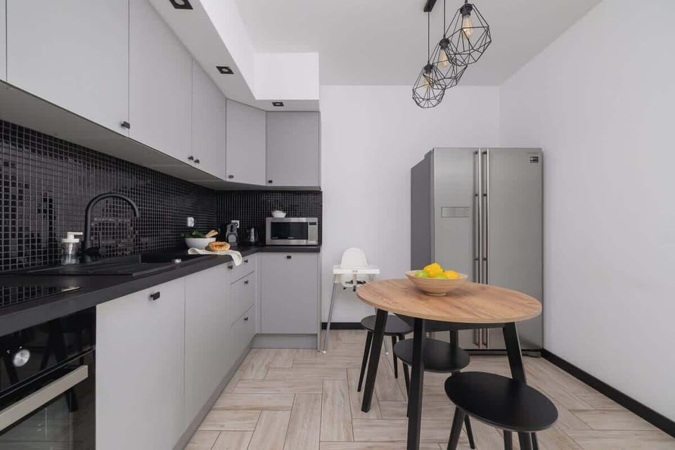 A view of the kitchen island and round dining table. The space is both functional and visually appealing.