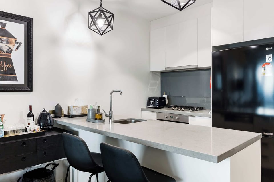 Modern kitchen with sleek countertops, appliances, and bar seating, perfect for home cooking or casual dining