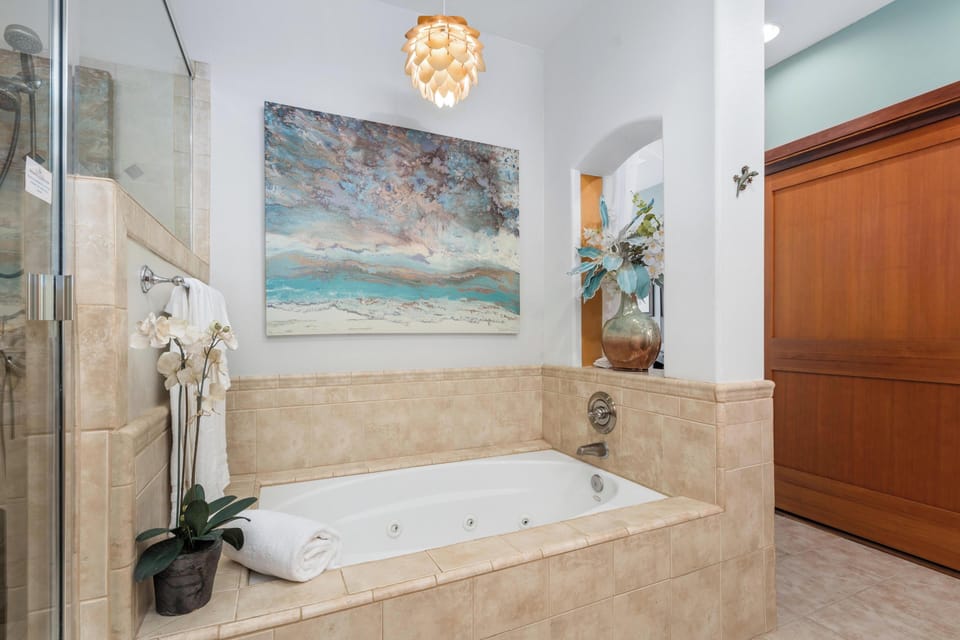 Ensuite primary bathroom with double vanity, walk-in shower, and soaking tub