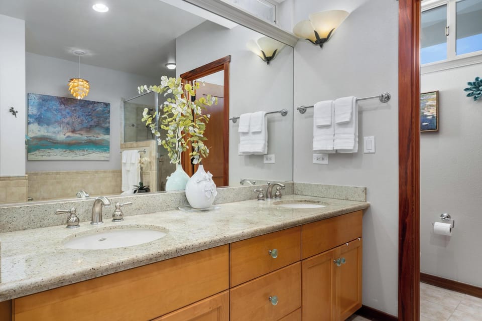 Ensuite primary bathroom with double vanity, walk-in shower, and soaking tub