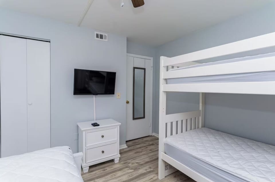 Bedroom view with closet, TV, dresser and mirror