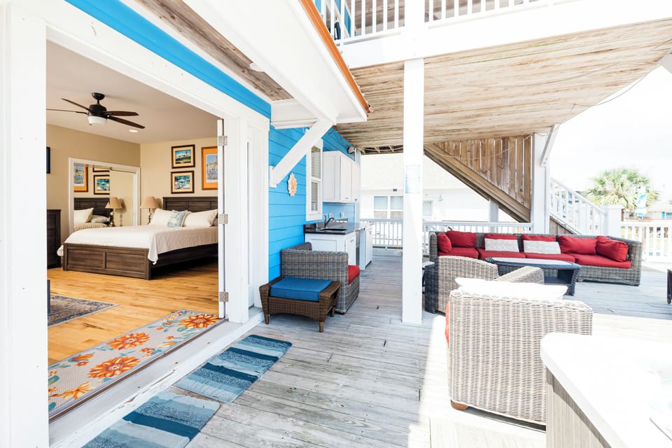 Unwind on your private deck with wicker seating and views, steps from your cozy bedroom retreat.