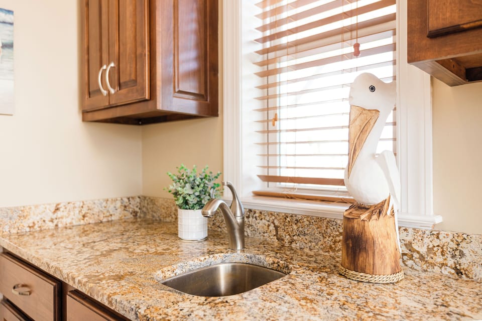 Step into your fully equipped kitchen where granite counters and warm wood cabinets create the perfect space for your culinary adventures.