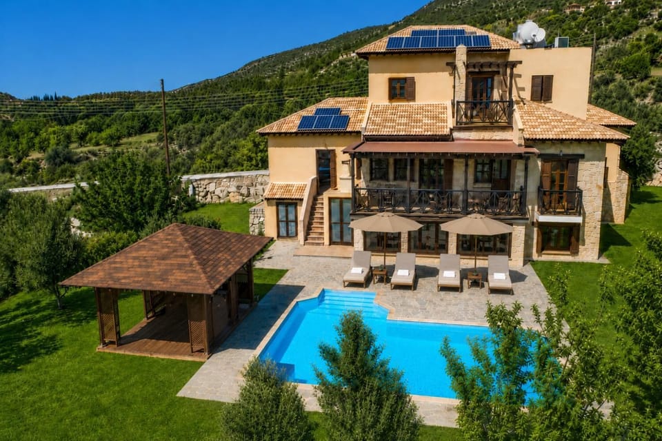 A luxurious hillside villa with a private pool, shaded gazebo, and beautiful green mountain views.