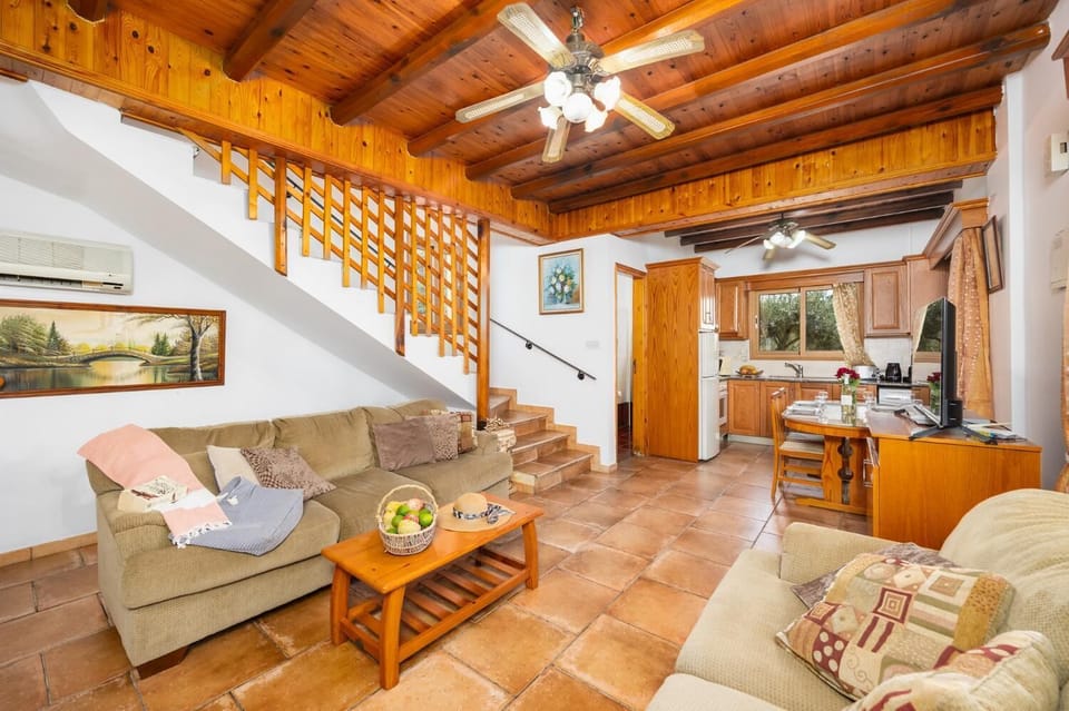 Open-plan living room with sofas, dining area, kitchen, A/C, WiFi internet, and satellite TV