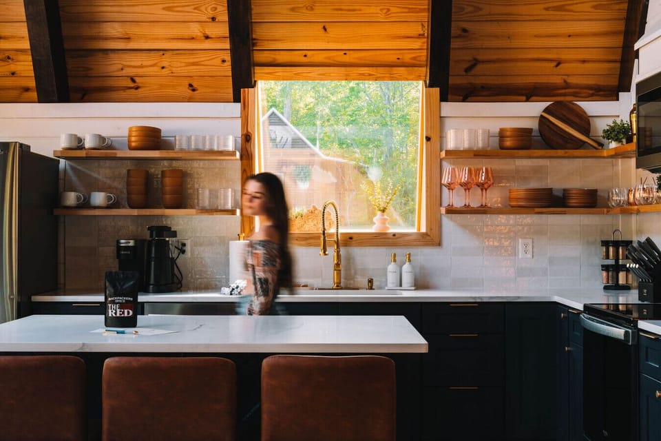 Floating shelves showcase stylish dinnerware in this modern and spacious kitchen.