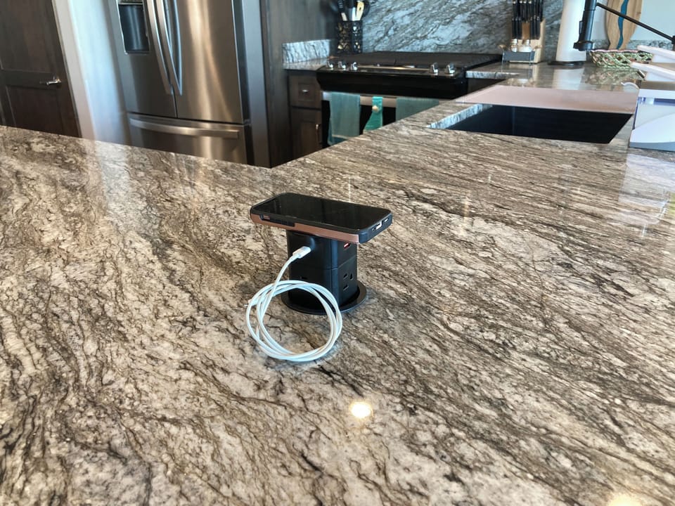 Pop-up phone charger.  Can handle several. Merely push down when not in use.