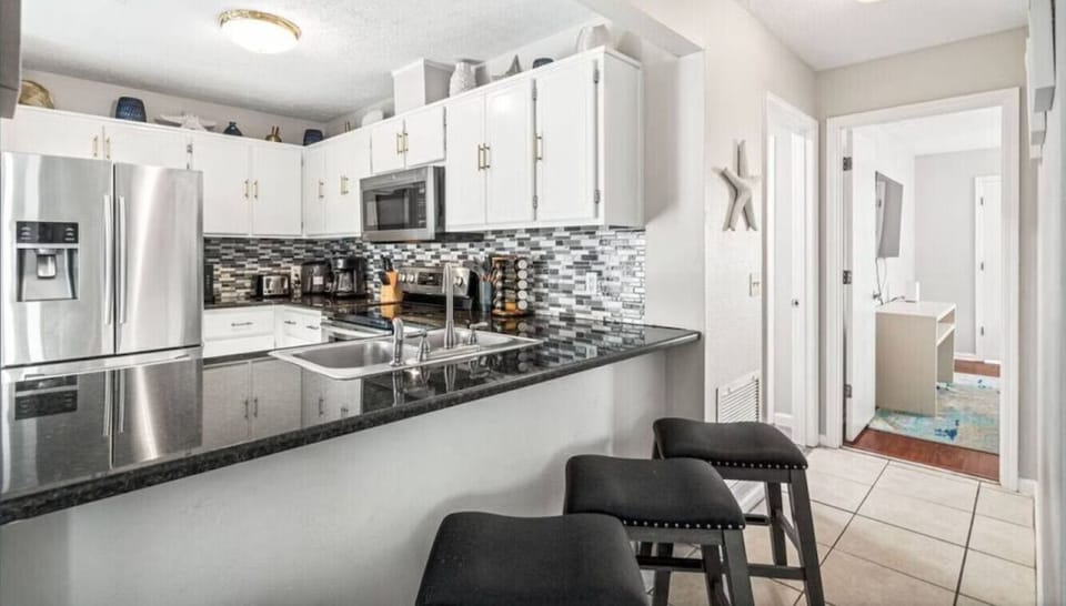 Cook up memorable meals in this sleek modern kitchen, featuring granite counters, stainless appliances, and stylish seating for your group.