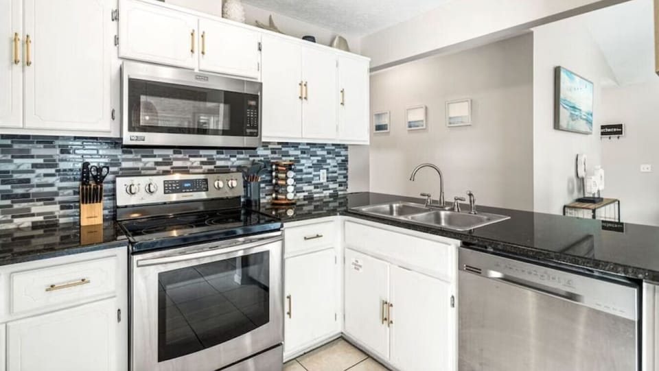 Your fully equipped kitchen features granite counters, stainless appliances, and modern tile backsplash—perfect for preparing your favorite meals.