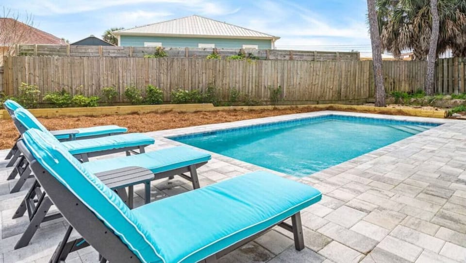 Dive into your private pool paradise with turquoise loungers perfectly positioned for sun-soaked relaxation in this peaceful backyard oasis.
