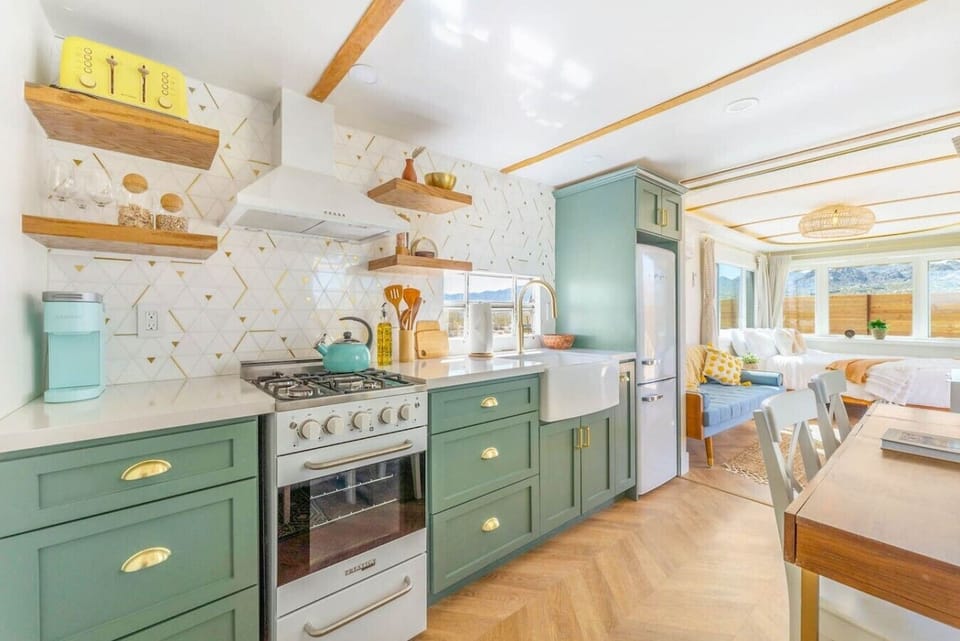 A custom kitchen blending retro charm with modern finishes, fully equipped and framed by stunning mountain views.