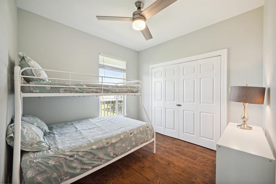 Fourth guestroom with a bunk bed, windows, and an ample closet for storage and clothes.