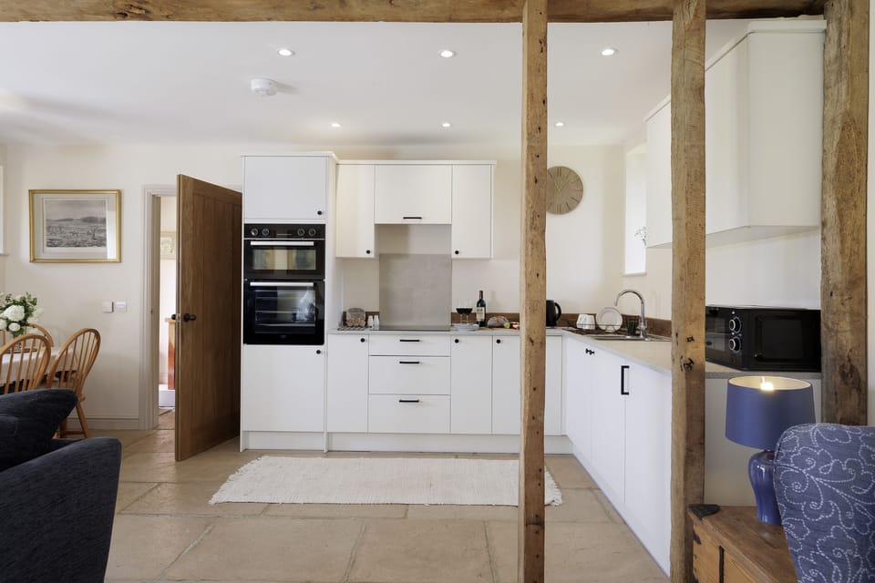 Wooden beams separate the kitchen and dining area from the sitting area