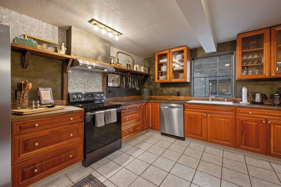 Kitchen includes oven, stovetop, dishwasher, farmhouse sink with disposal and a large refrigerator