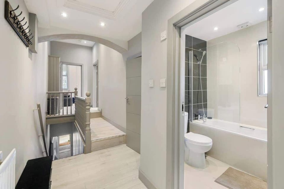 - Bright hallway with modern flooring leading into bathroom area  
- Open access shows sleek design with tub shower and practical use  
- Airbnb layout crafted for easy flow and comfortable guest stays  
