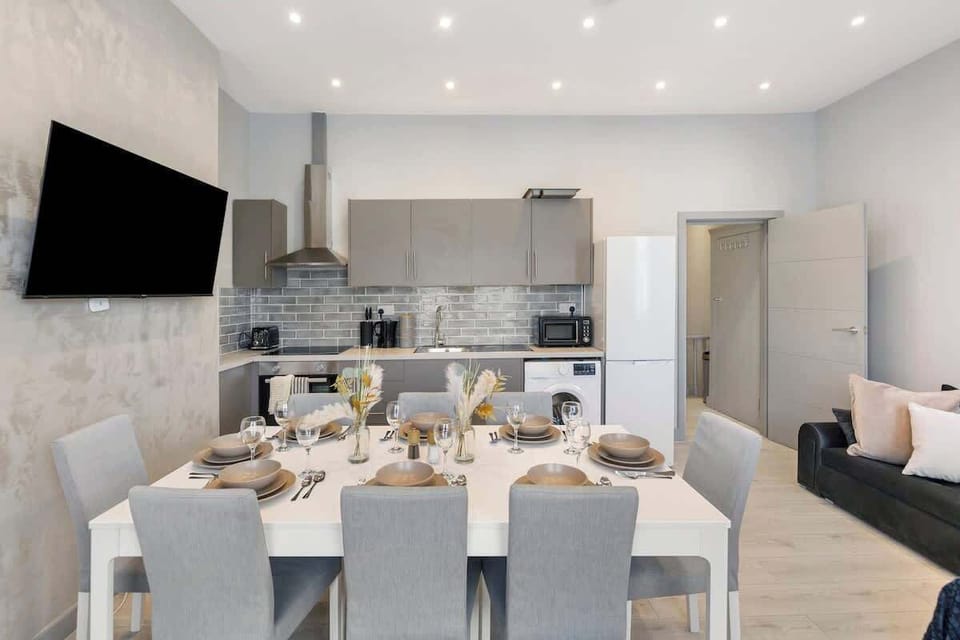 - Gather around this spacious dining table perfect for group meals  
- Modern open plan kitchen with sleek cabinets and tiled backsplash  
- Enjoy cooking hosting or watching the flat screen TV while dining  
