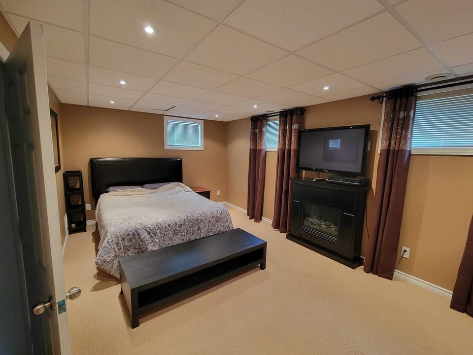 Large bedroom with ample storage, sunny windows, and carpeted flooring. 