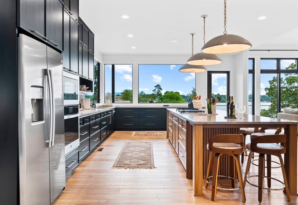 Cooking is a joy in this spacious kitchen, complete with sleek black cabinets and vibrant art. The open layout is perfect for entertaining.