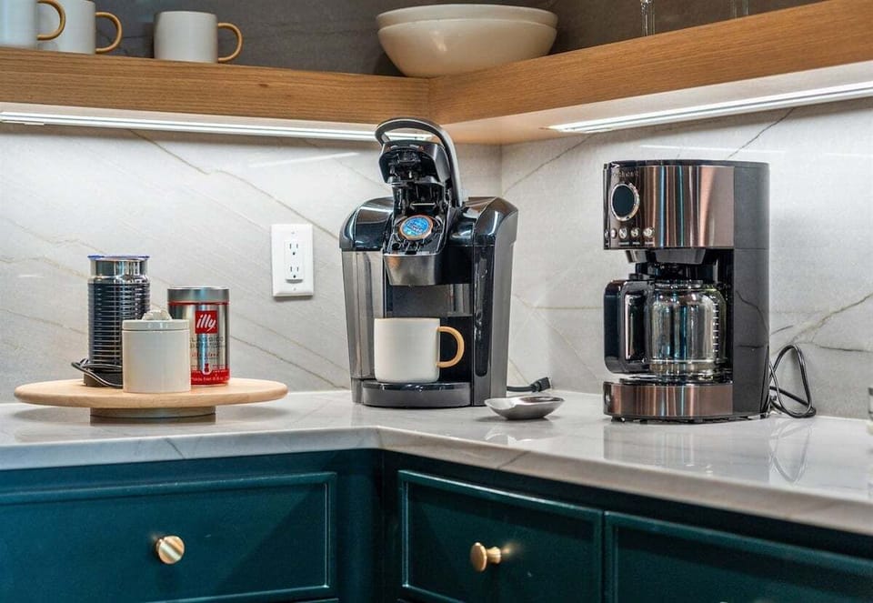 Start your day right with a fresh cup of coffee from this well-equipped kitchen corner. The stylish appliances and thoughtful design make it a perfect spot for your morning routine.