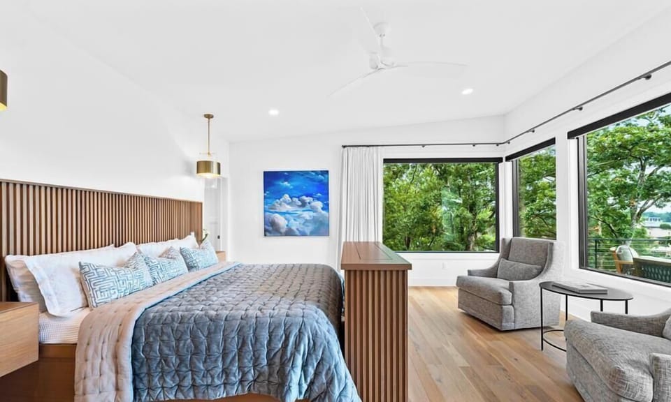 Enjoy the luxurious comfort of this king bedroom, complete with expansive windows and elegant furnishings.