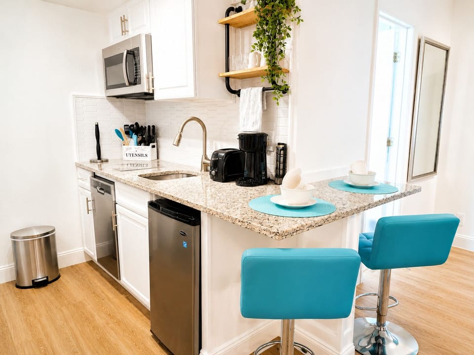 Fully equipped kitchen with refrigerator, cooktop, microwave, coffee maker, toaster, dishwasher, cookware, dishes, utensils, and all the essentials needed for everyday cooking.