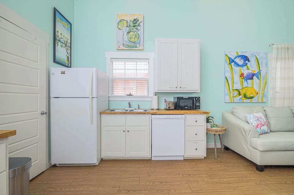 Full-size fridge and cupboard full of dishes