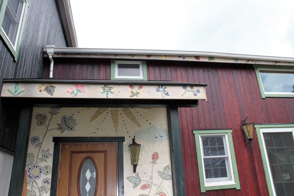 The front entrance/mosaic tiles are designed with wild strawberries and hollyhocks.