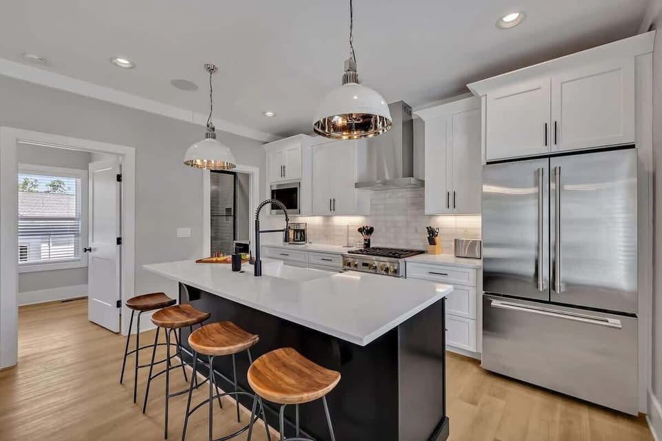 (Unit 1) 2nd Floor: Fully equipped kitchen, complete with all essential culinary tools, boasts stainless-steel appliances and a spacious island with ample counter space and bar seating.