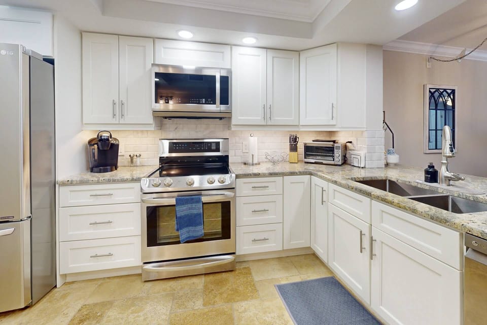 Fully equipped kitchen with modern appliances, including a refrigerator, stove, microwave, and dishwasher.