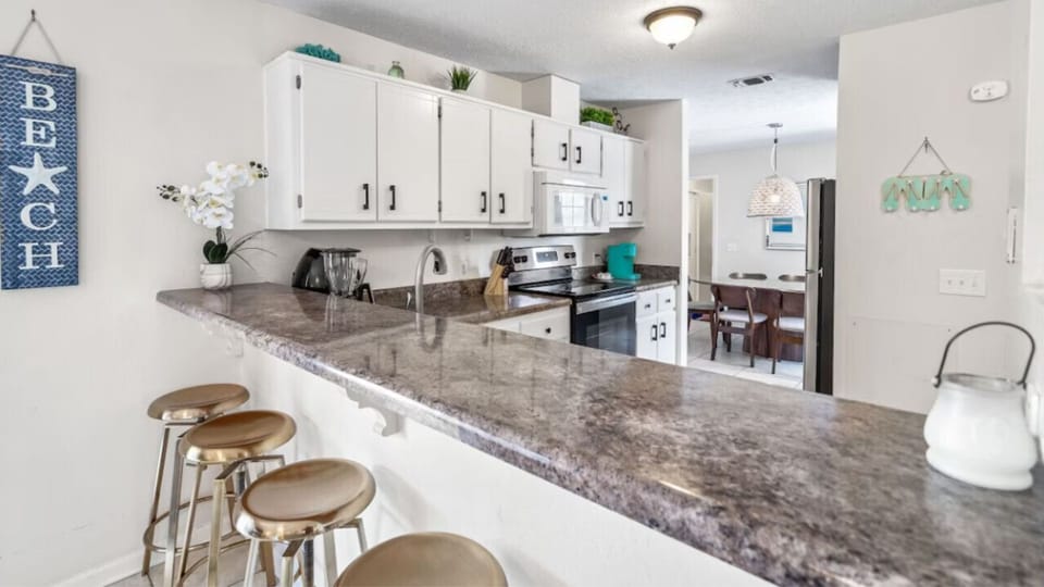 Your spacious kitchen features granite countertops, full appliances, and breakfast bar seating perfect for morning coffee or casual dining.
