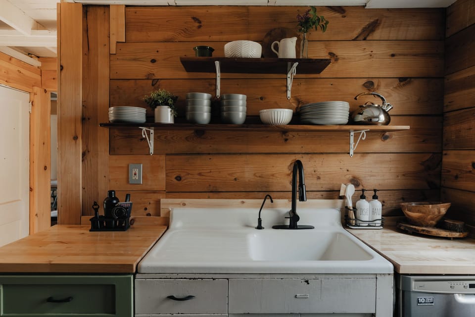 Encircled by sturdy stone walls that echo with stories of generations past, this space welcomes you with a farmhouse sink and sleek, contemporary appliances. 