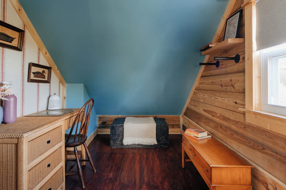 Relax in the tranquil blue room, featuring a queen bed, desk area, and peaceful atmosphere perfect for work or rest.
