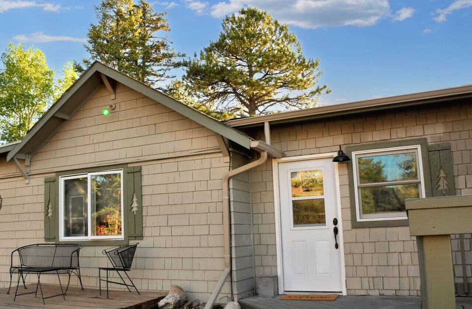 Charming exterior view of the cabin with a small patio, ideal for enjoying the fresh mountain air and serene surroundings