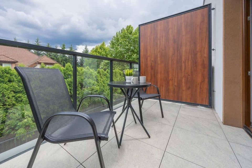 Balcony angle with wood paneling – Stylish and private outdoor seating area.

