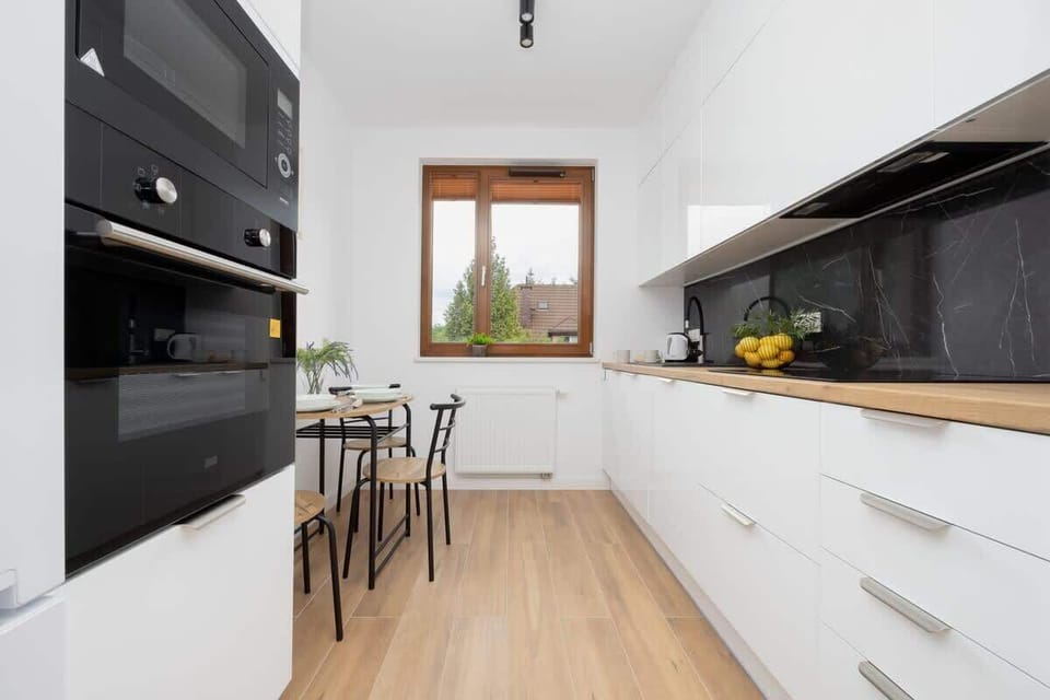 Modern kitchen with black backsplash – Fully equipped with stovetop, oven, and all essentials.
