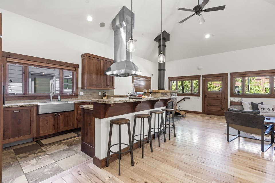 The breakfast bar with four barstools overlooks the kitchen with beautiful wood cabinets and window over the sink.