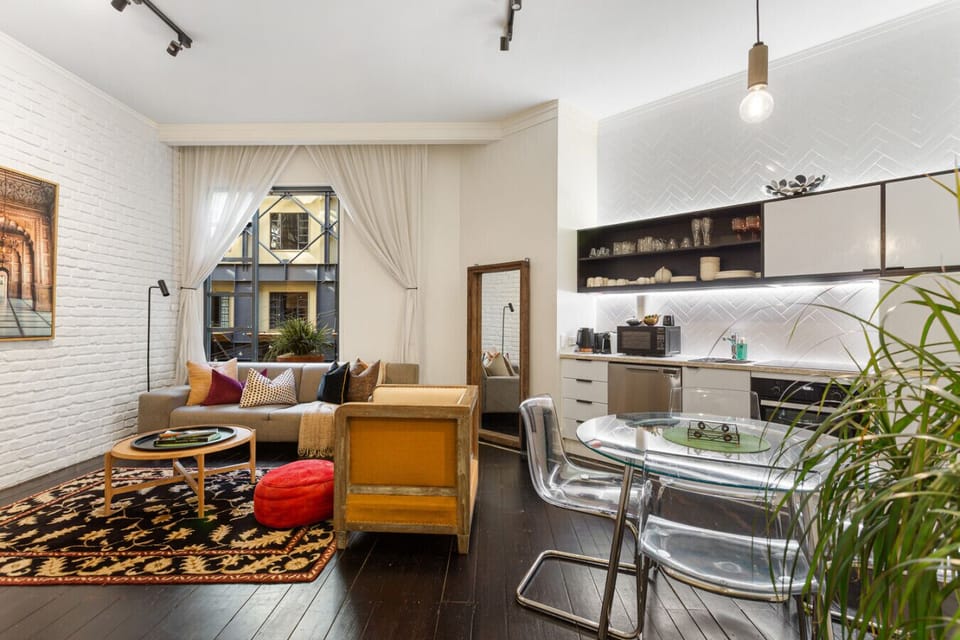Stylish and functional living room with seamless kitchen access and warm natural light.