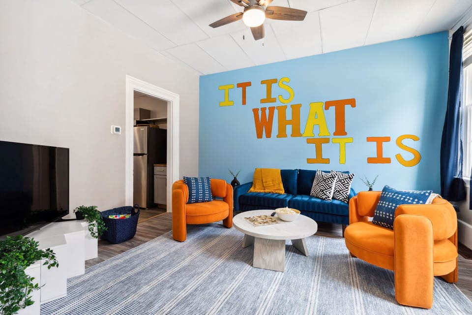 Eclectic living room with ceiling fan and TV
