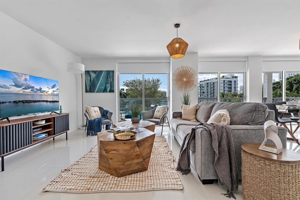 Spacious modern living room with Smart TV, dining area, and balcony at Bay Harbor Islands vacation rental near Miami Beach and Bal Harbour Shops