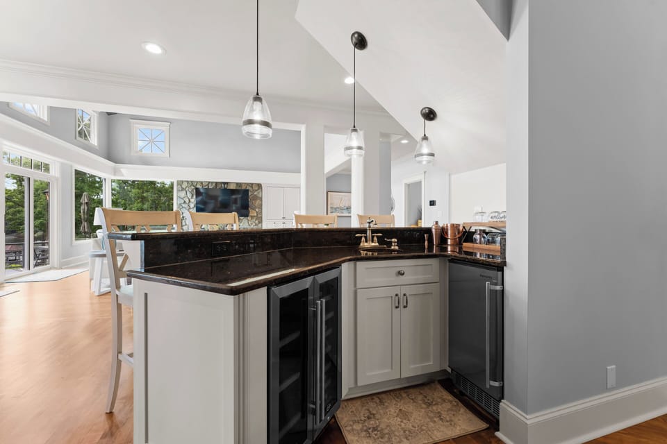 Wet bar with beverage fridge, ice maker  and barstools. 