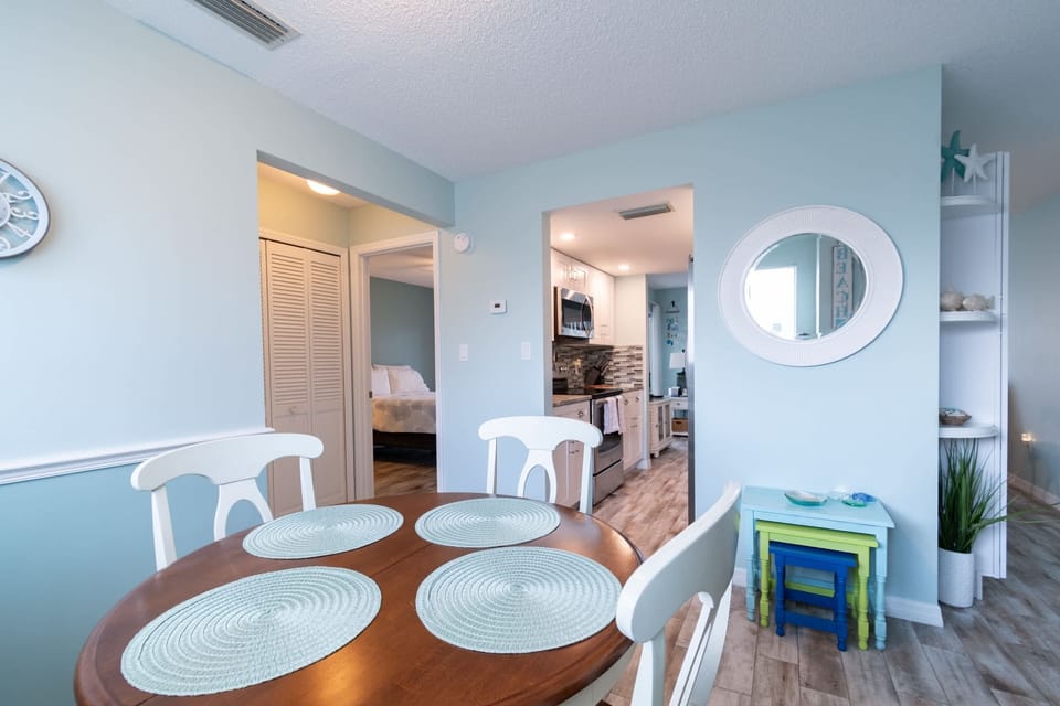 Cozy dining area with a view into the modern kitchen and bedroom.