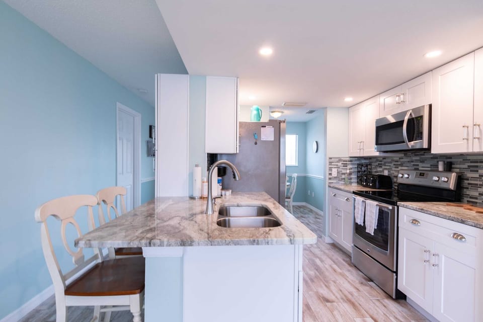 Modern kitchen with marble countertops and stainless steel appliances