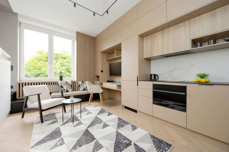 Sleek kitchenette and living combo – Smart design with warm tones and under-cabinet lighting.

