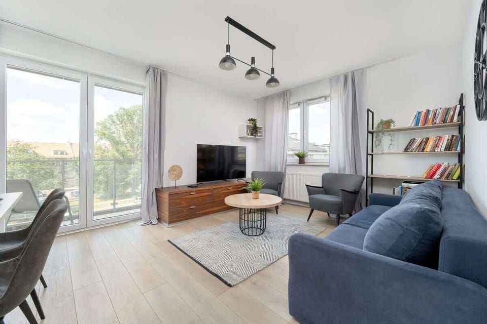 Open, sunlit room with a comfortable sofa and access to the balcony.