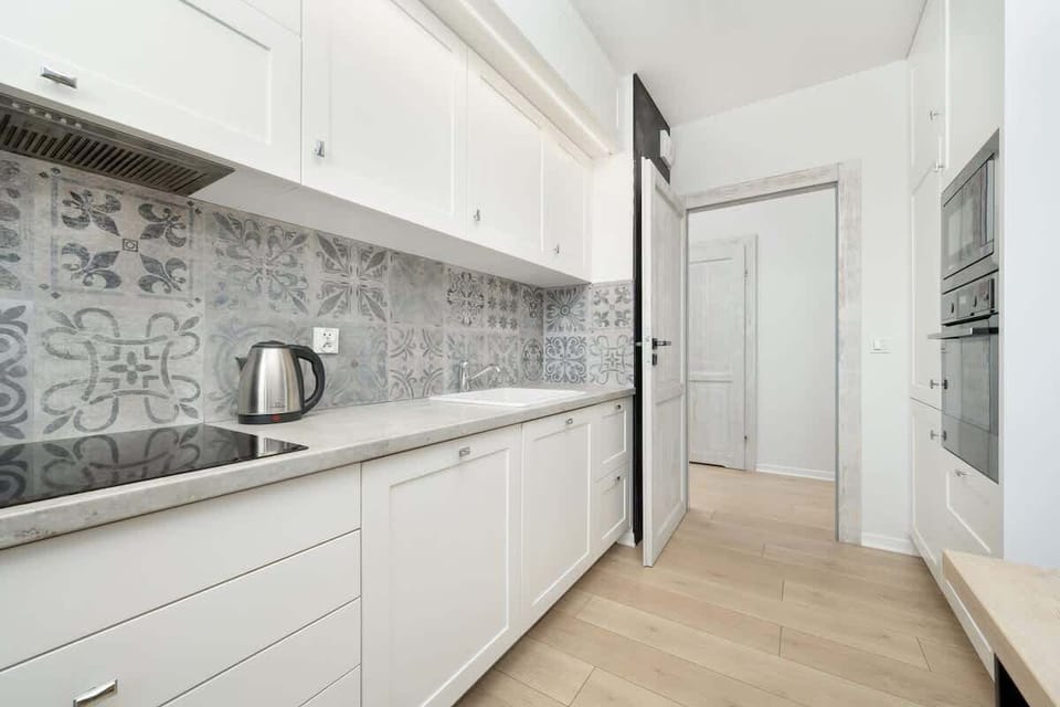 White cabinets, electric oven, and ample countertop space.